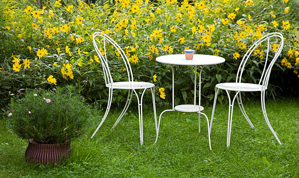Table et chaises de jardin entourées de fleurs jaunes
