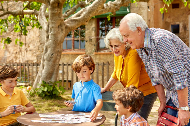 Famille avec petits-enfants et grands-parents en train de jouer dans le jardin