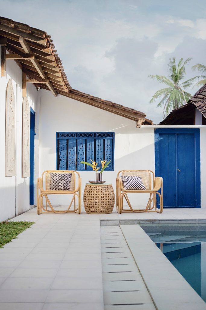 terrasse avec piscine et salon de jardin en rotin