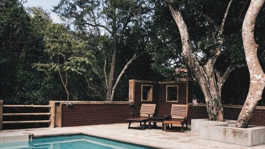 piscine extérieure avec revêtement de sol en béton et transats en bois